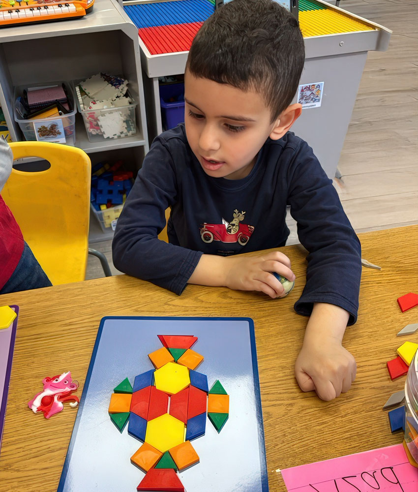 A young boy joyfully plays with a vibrant puzzle, demonstrating his problem-solving skills and creativity.